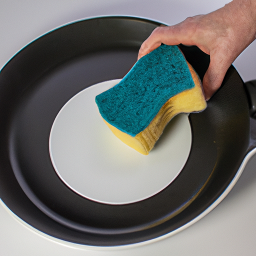 A person gently scrubbing non-stick cookware with a soft sponge.